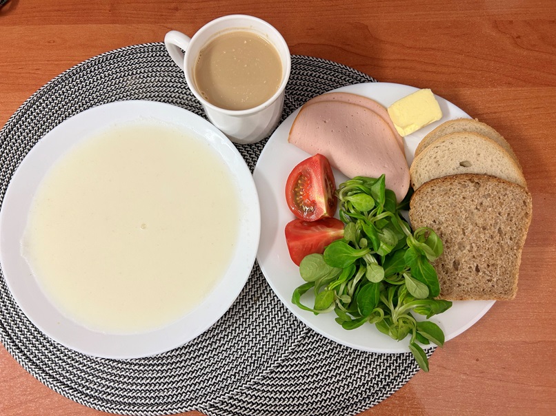 Na zdjęciu: Kasza manna na mleku, Kawa zbożowa z mlekiem, Chleb mieszany pszenno-żytni, Chleb Graham, Masło extra 82%, Filet zapiekany drobiowy, Pomidor, Roszponka